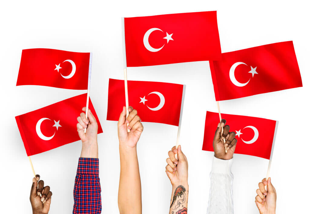 Hands waving flags of Turkey